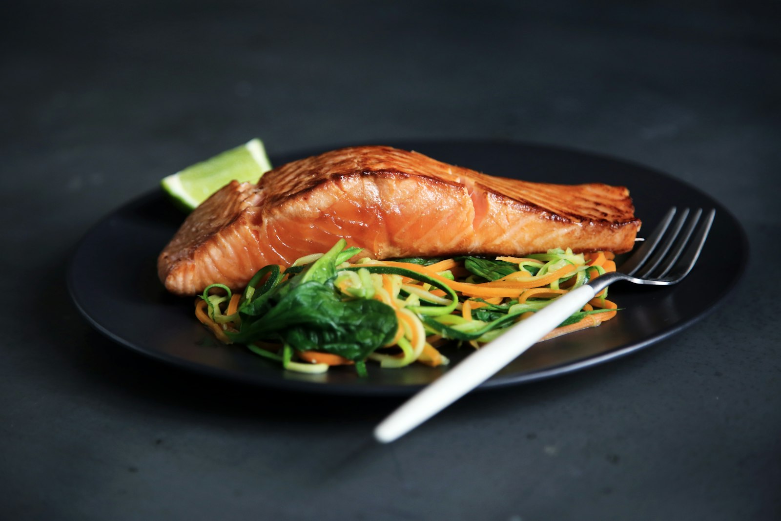 Pan-seared fish plated over garden vegetables