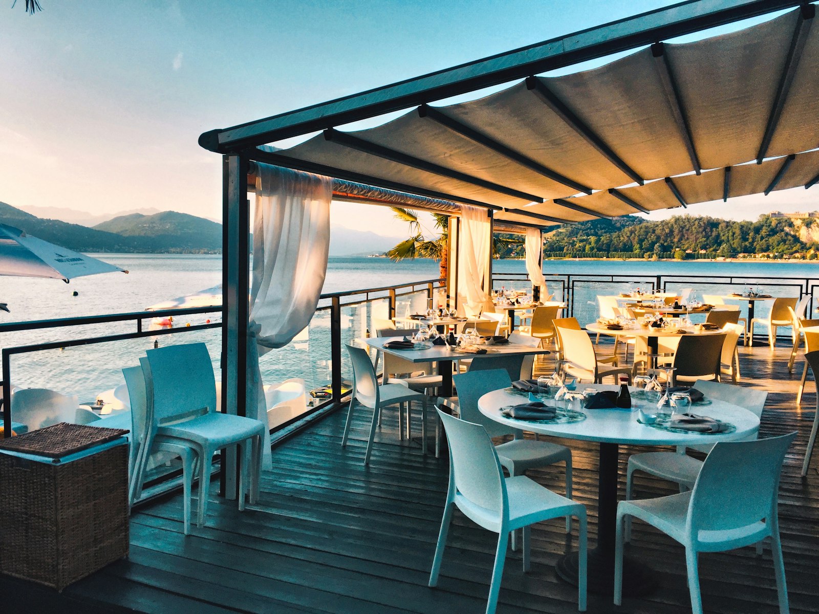 Tables set on the lakeside patio at golden hour